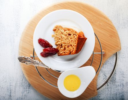 Slice of date cake and dates on a wooden surface