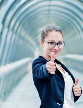 Successful business woman with thumbs up out of office