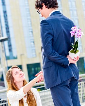 Male offering flowers to his working partner