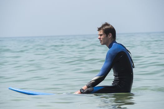 Young boy surfing in the sea, waiting waves