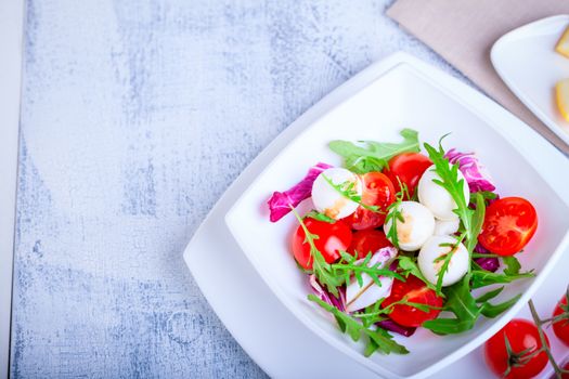 Fresh mozzarella balls served with spicy rocket leaves and cherry tomatoes.