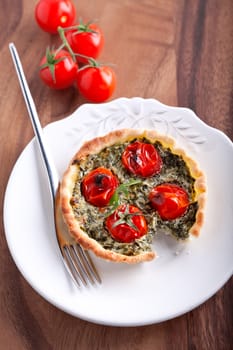 Mini Spinach Quiche with a fork served on a white plate