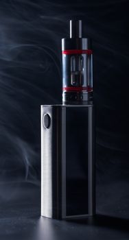 Electronic cigarette on a black background in smoke