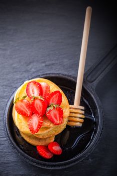 Stack of sweet pancakes with strawberry and honey. Gluten free flour.