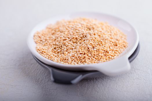 Raw quinoa seeds placed on wooden table