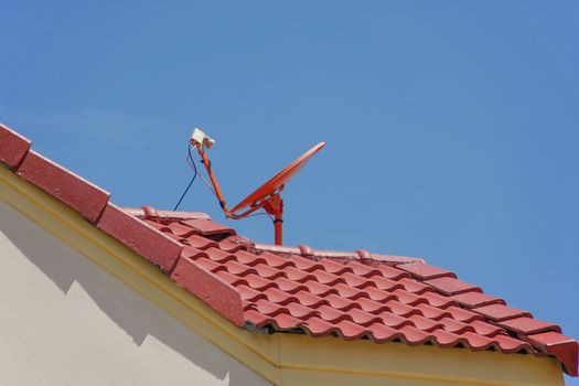 red roof with a satellite dish and blue sky