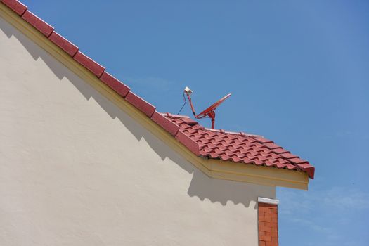 red roof with a satellite dish and blue sky