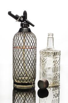 Siphon, bottle and tap on a glass studio background