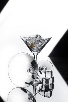 Two glasses and crystals of ice on a glass studio background