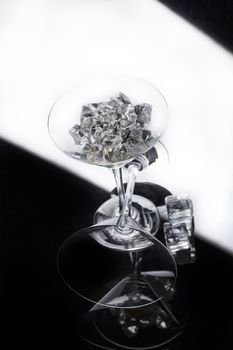 Two glasses and crystals of ice on a glass studio background