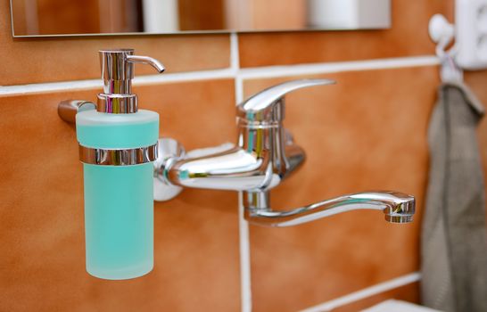 Closeup of a Soap Dispenser and Other Equipment in Bathroom.