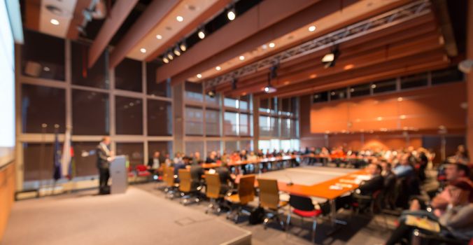 Speaker giving a talk on corporate business event. Audience at the conference hall. Business and Entrepreneurship event. Out of focus image. Unrecognizable business people.