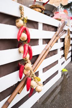 Garlic and hot chili peppers hanging on  white wooden background outdoor.