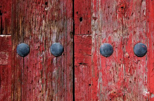 Old Red Cracked Wooden Background with Rivets closeup Outdoors