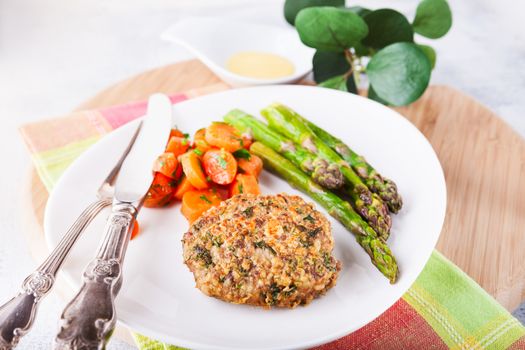 Meat rissole with glazed carrots, asparagus on the plate 