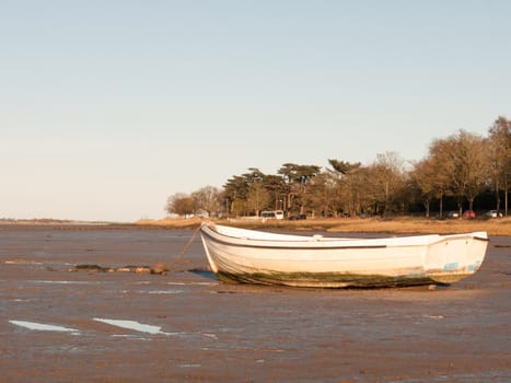 A boat standing stationary in the in mud with the tide out