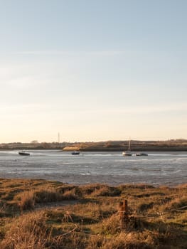 A wonderful shot of the river and its bank with the tide out on a clear day with boats
