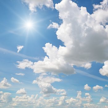   sun on blue sky with white clouds                                  