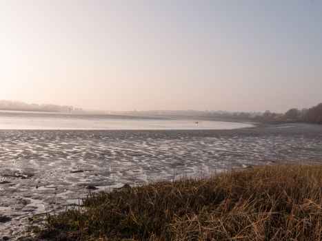 Various shots of the river and the mud, along with many birds, buoys, and other sea structures, as the sun sets