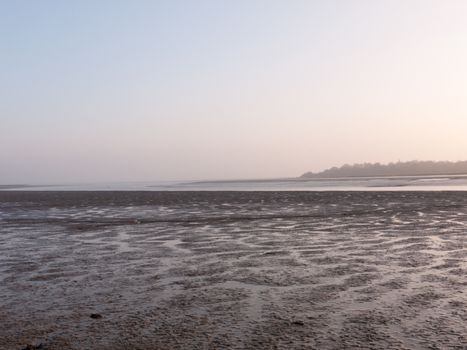 Various shots of the river and the mud, along with many birds, buoys, and other sea structures, as the sun sets