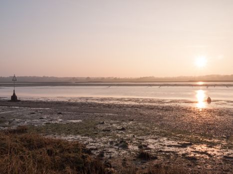 Various shots of the river and the mud, along with many birds, buoys, and other sea structures, as the sun sets