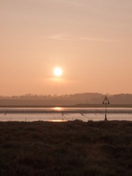 Various shots of the river and the mud, along with many birds, buoys, and other sea structures, as the sun sets