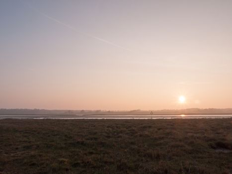 Various shots of the river and the mud, along with many birds, buoys, and other sea structures, as the sun sets