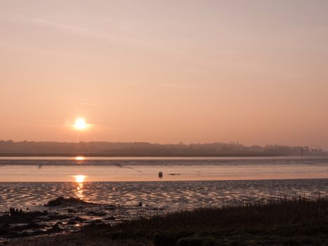 Various shots of the river and the mud, along with many birds, buoys, and other sea structures, as the sun sets