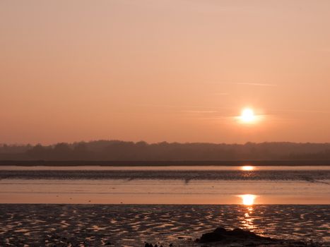 Various shots of the river and the mud, along with many birds, buoys, and other sea structures, as the sun sets