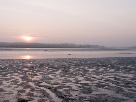 Various shots of the river and the mud, along with many birds, buoys, and other sea structures, as the sun sets