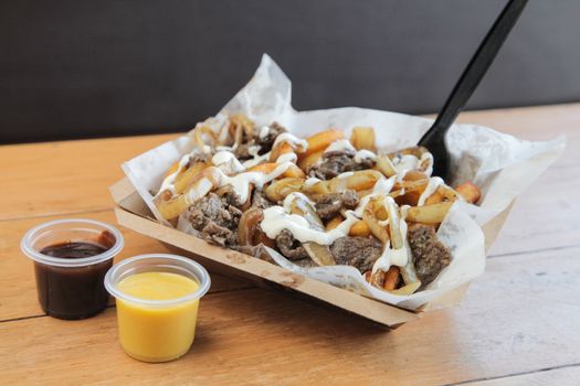 Poutine Curly fries with beef meat topped with cheese and mayo

