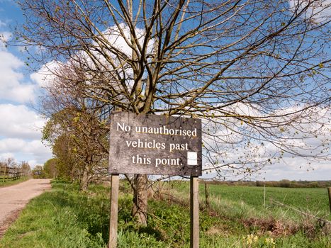 A Sign that Says No Unauthorised Vehicles Past this Poing in the Countryside on a sunny day, Wooden Sign with old Font and Type, No Cars, No People, Private, Special, Parking, Personal, Farmland, Fenced