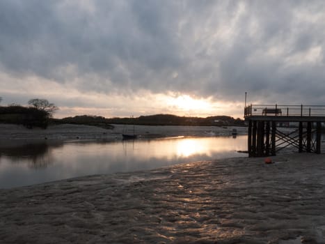 Low tide river with boats, a pier and more