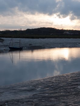 Low tide river with boats, a pier and more