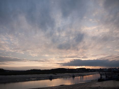 Low tide river with boats, a pier and more