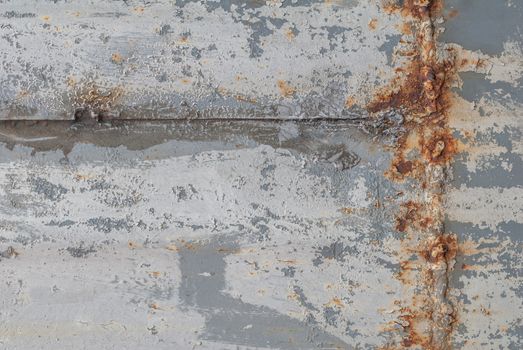 rusty iron surface covered with old chipped grey color paint, which has long been influenced by different climatic conditions