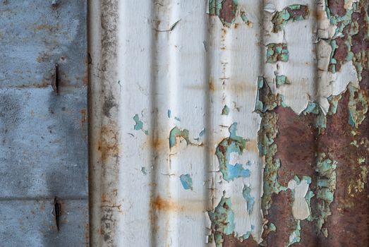 rusty iron surface covered with old chipped grey color paint, which has long been influenced by different climatic conditions