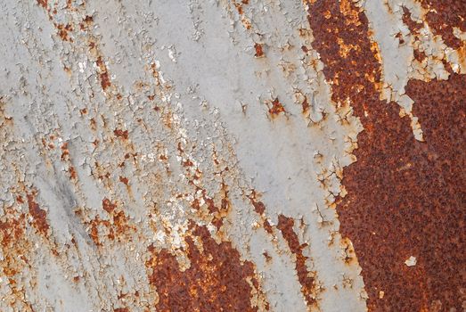 rusty iron surface covered with old chipped grey color paint, which has long been influenced by different climatic conditions