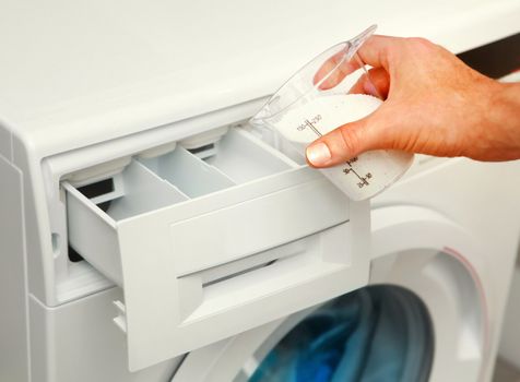 hand of man that fills detergent in the washing machine