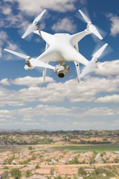 Unmanned Aircraft System (UAV) Quadcopter Drone In The Air Over Rural Neighborhood Houses.