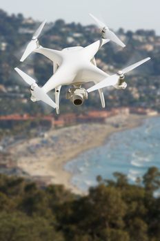 Unmanned Aircraft System (UAV) Quadcopter Drone In The Air Over The Ocean Coastline.