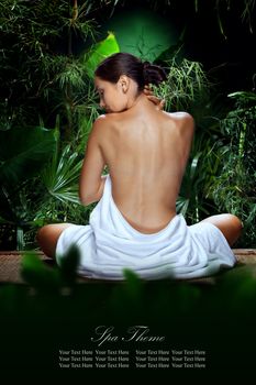View of nice young woman meditating in spa tropic environment