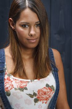 portrait of a twenty something girl against a blue stain wood background