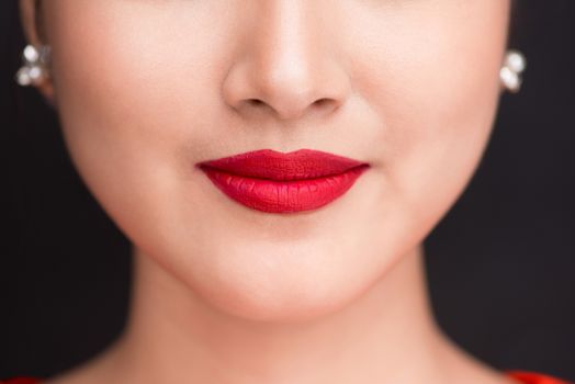 Beauty. Close up view of beautiful woman lips with red matt lipstick