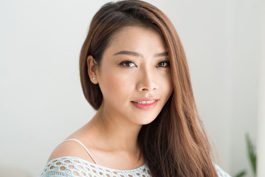 Beautiful asian woman relaxing in the morning sitting indoors.