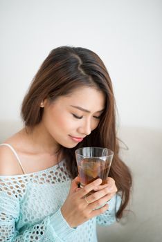 Beautiful young asian woman drinking her morning tea over a breakfast at home.