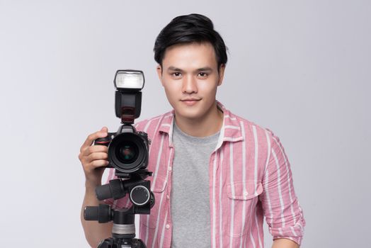 Young asian photographer holding digital camera, while working in studio