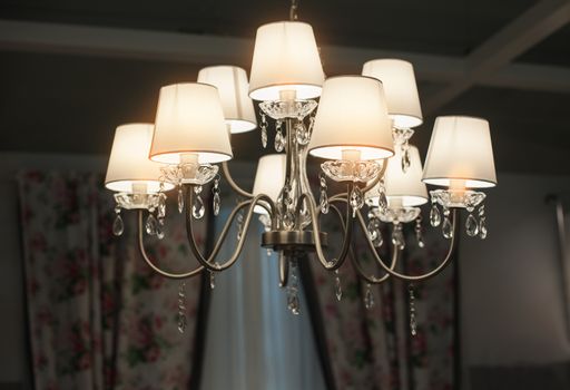 Beautiful luxurious chandelier in the hall of building.