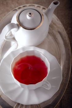 A cup of Red fruit tea with a kettle