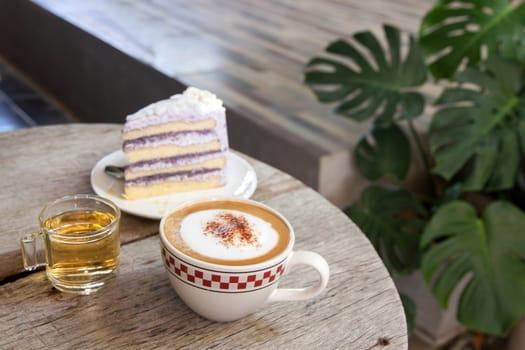 Coffee Break taro cake and Cappuccino coffee on wood table